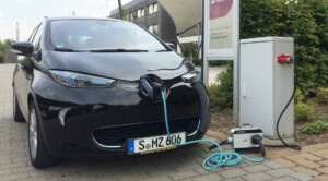 Ein Renault ZOE lädt mit einer mobilen Wallbox an einer Drehstromsteckdose.